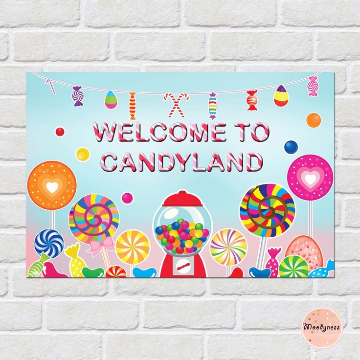 a welcome sign on a brick wall with candy land candies and lollipops