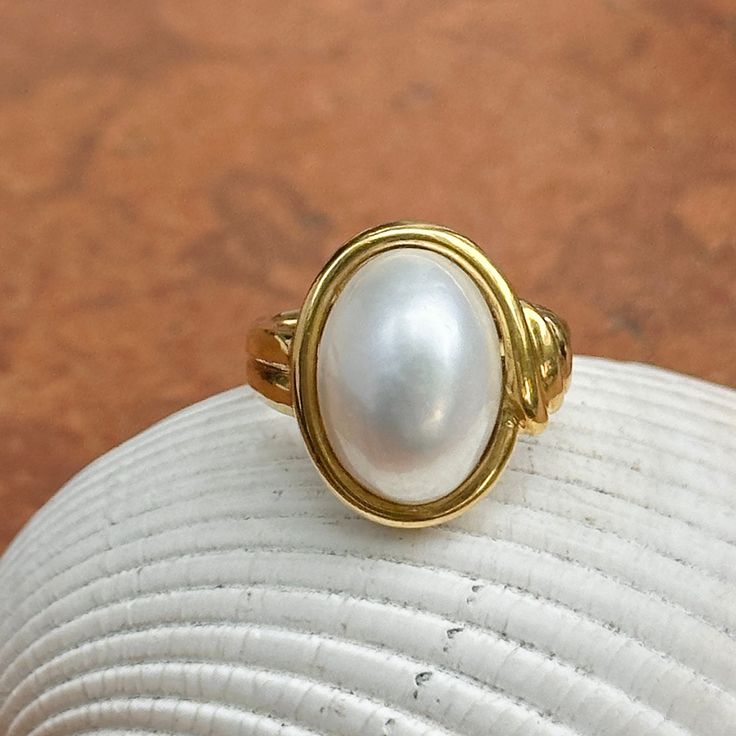 New, but old pieces, never worn, recently acquired from a premier jeweler located in Minneapolis, MN for many years- a rare opportunity! 18KT yellow Ggld genuine, bezel-set, white, oval, mabe pearl ring. Size 6.75 Sizable by us for a fee or your local jeweler Weight: 10.3 grams Band width: 3mm in back Pearl measures: 15mm x 11mm oval mabe pearl Stamped 18k By Honora Timeless Oval Rings With High Luster, Oval Yellow Gold Pearl Ring With High Luster, Oval Pearl Ring In Yellow Gold With High Luster, Yellow Gold Oval Pearl Ring With Polished Finish, Heirloom High Luster Oval Pearl Ring, Classic Cabochon Pearl Ring For Formal Occasions, Classic Oval Ring With High Luster, Classic Oval Rings With High Luster, Gold Oval Cabochon Pearl Ring