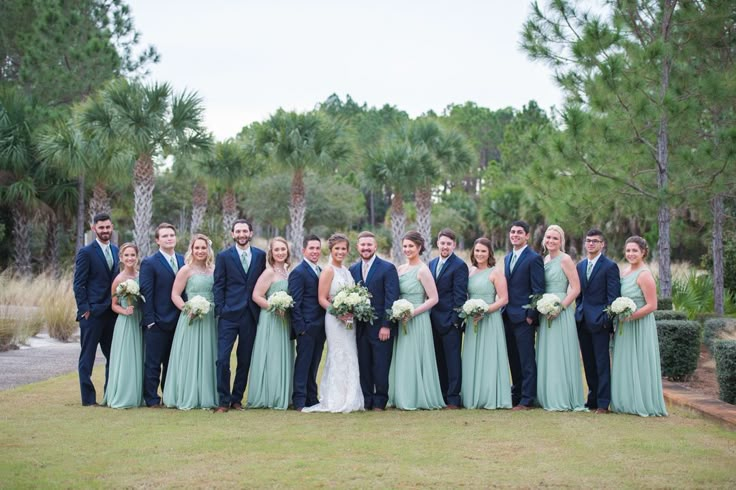 a group of people standing next to each other in front of trees