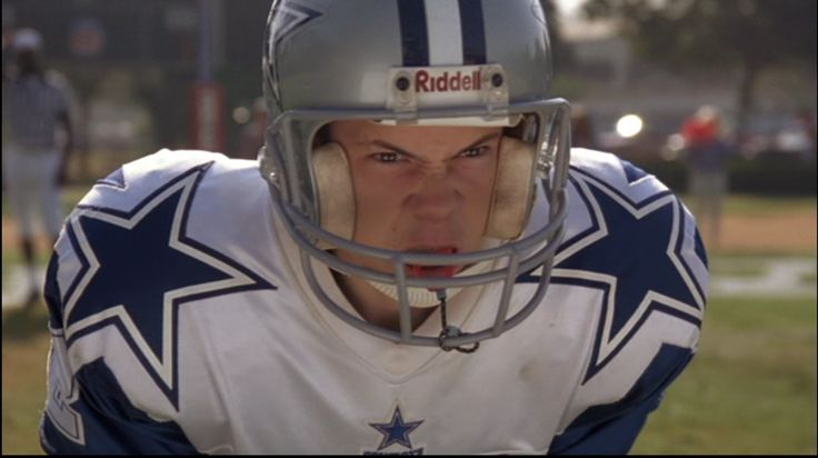 a close up of a football player wearing a helmet and making a face with his mouth open