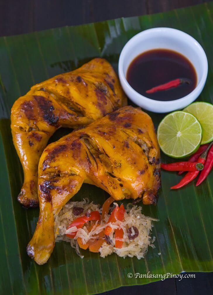 some food is laying out on a banana leaf next to a bowl of dipping sauce