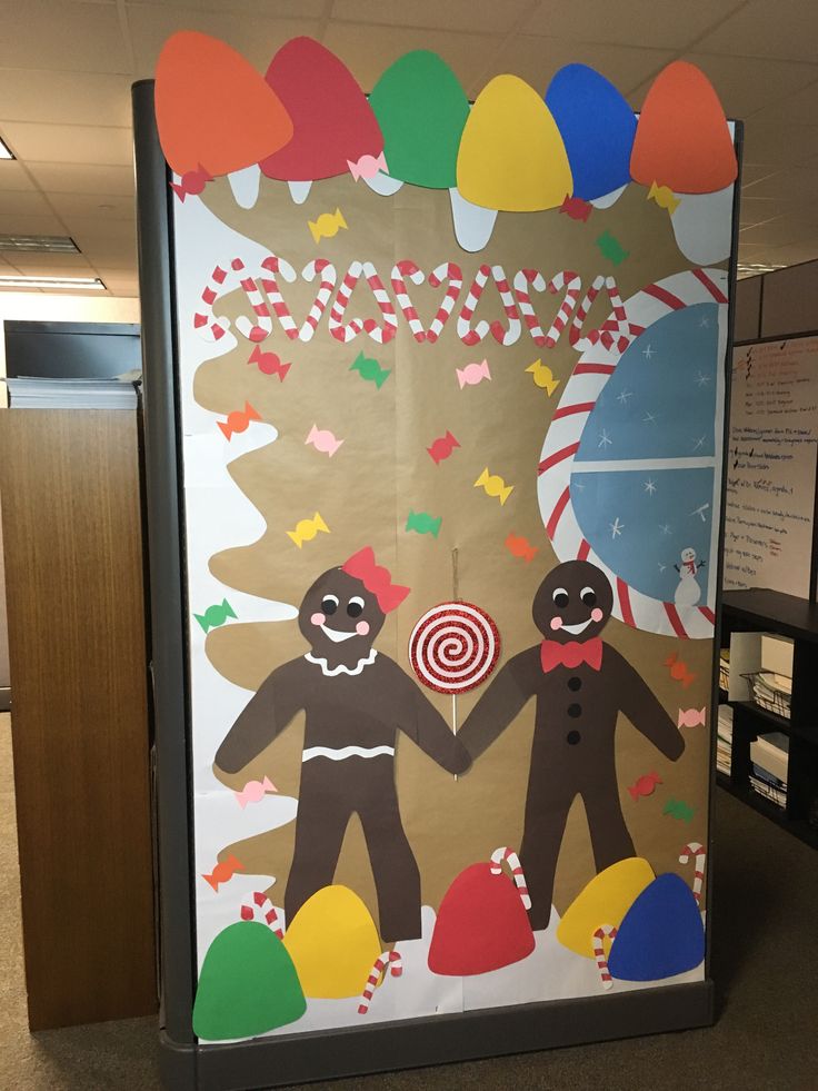 an office cubicle decorated to look like two gingerbread men holding hands with candy canes