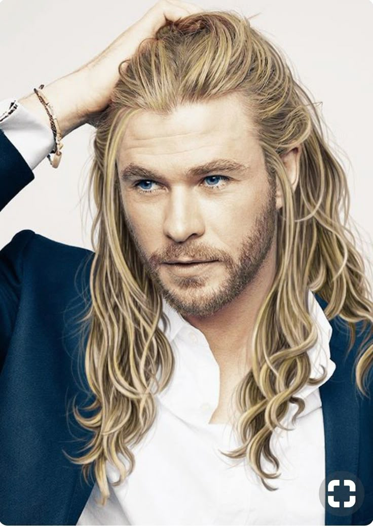 a man with long blonde hair and blue eyes wearing a suit over a white shirt