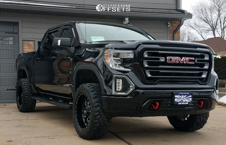 a black truck parked in front of a garage