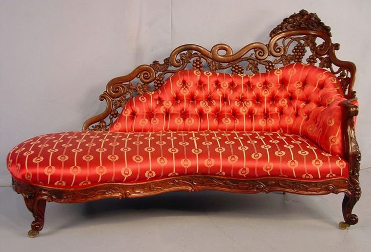 an old fashioned couch with red upholstered fabric