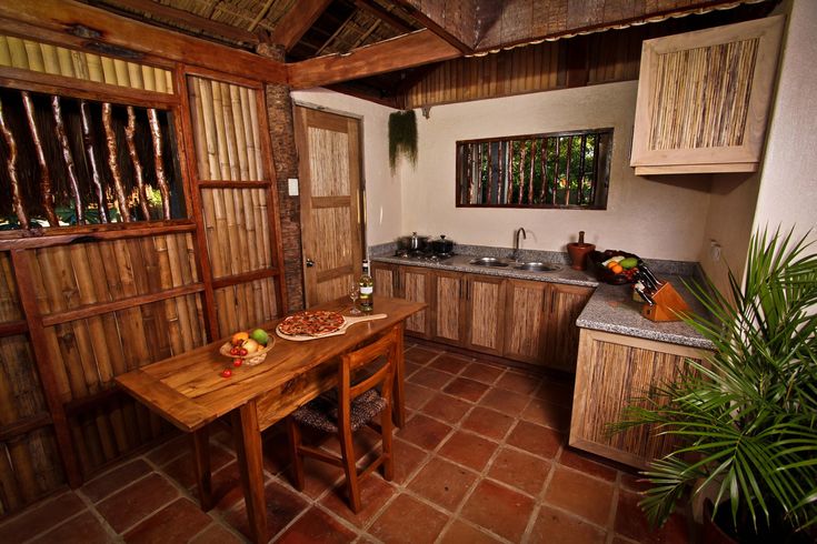 a wooden table sitting in the middle of a kitchen next to a sink and window