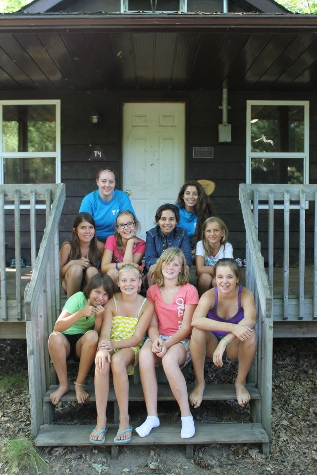 a group of people sitting on steps in front of a house