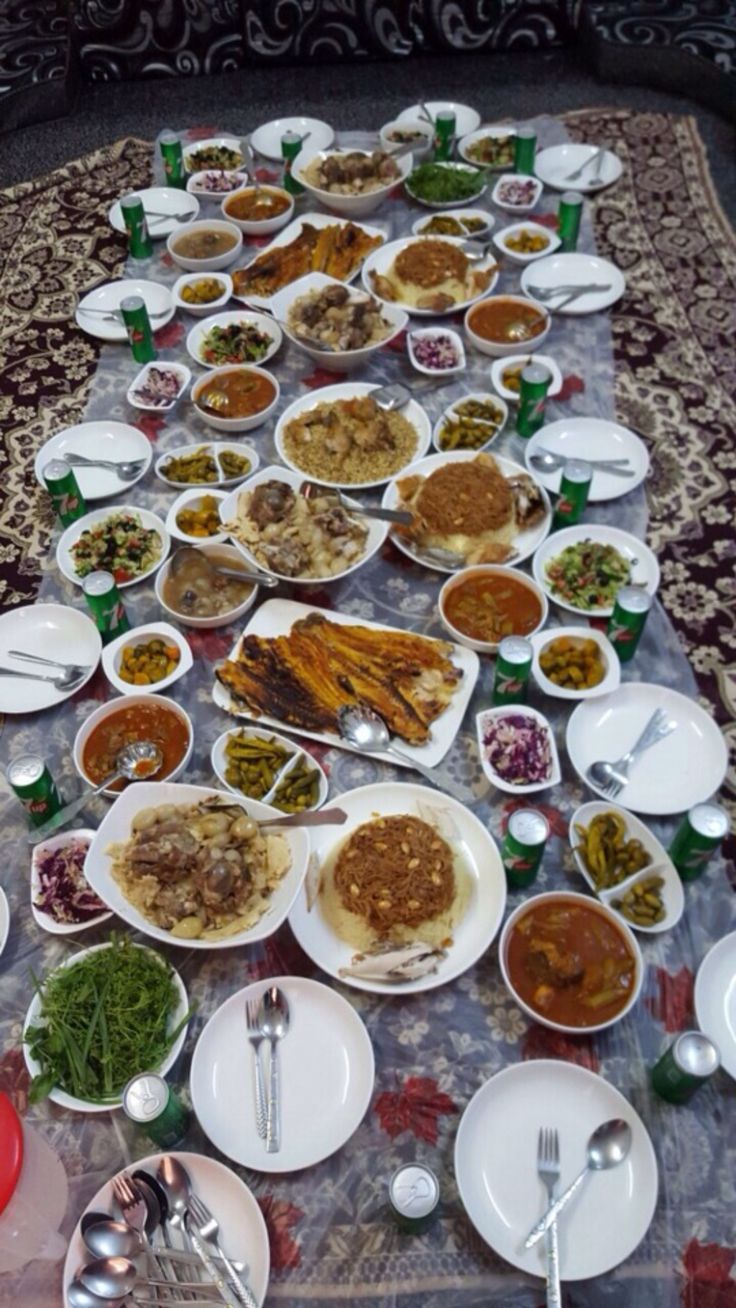 a long table covered with plates and bowls filled with different types of food on it