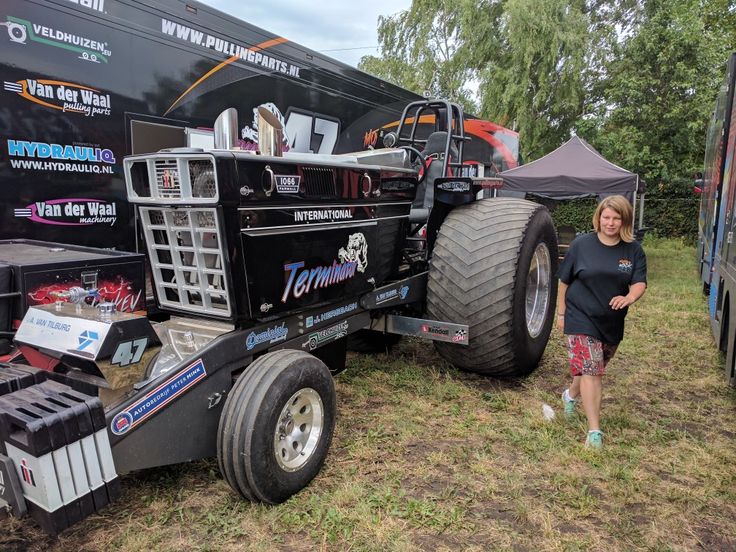 a woman standing next to a tractor trailer