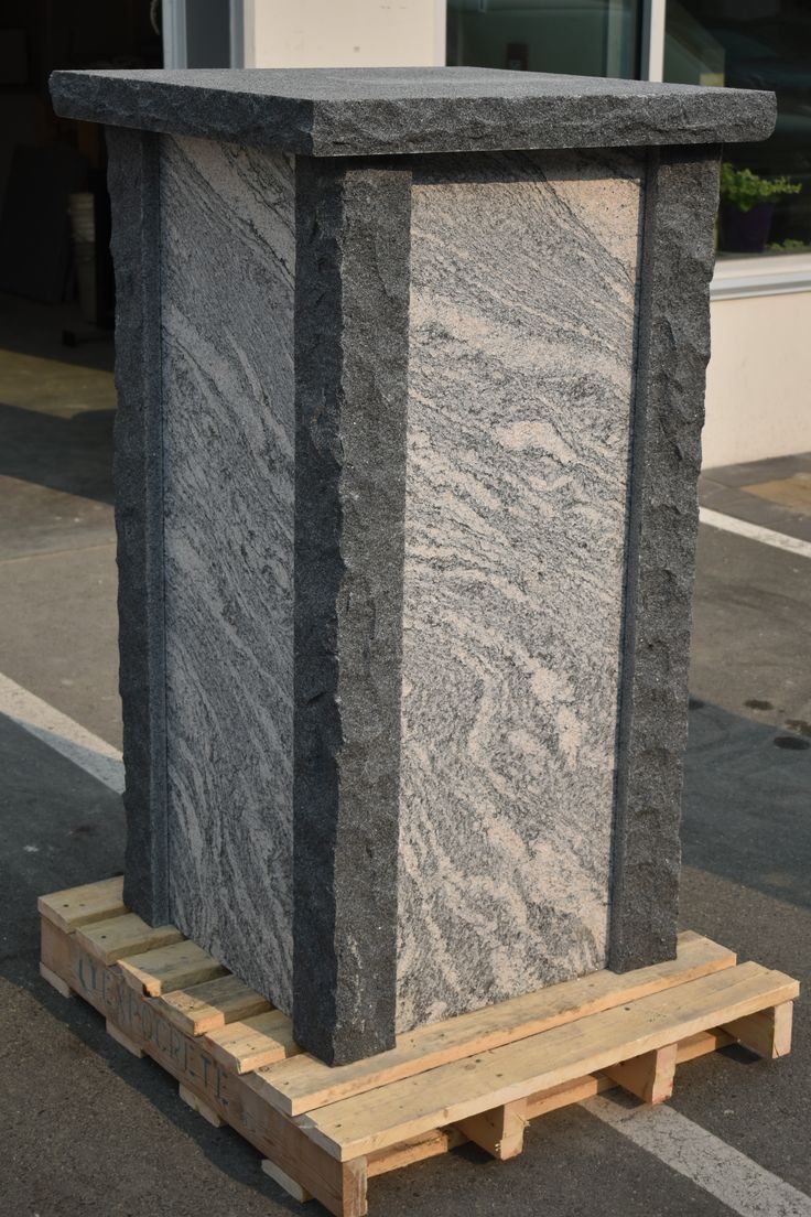 a large stone block sitting on pallets in front of a building