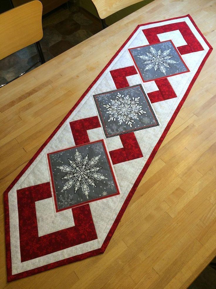 a table runner with snowflakes on it sitting on top of a wooden floor