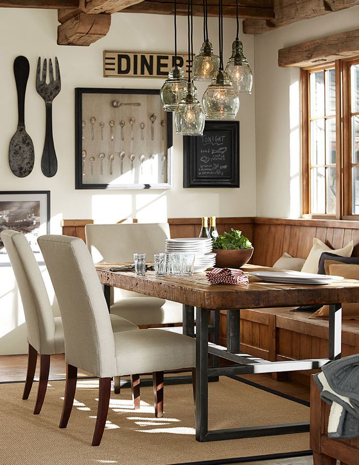 a dining room table with chairs and utensils hanging from the wall above it