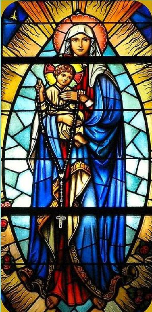 a stained glass window with the image of mary and jesus holding a baby in her arms