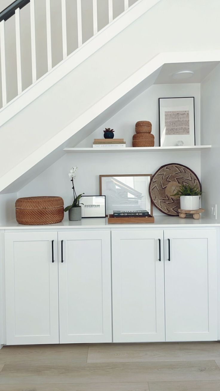 a room with white cabinets under the stairs