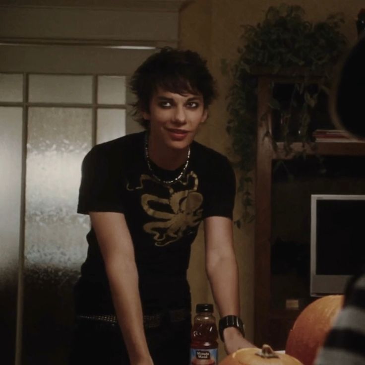 a woman standing in front of a table with food on it and a bottle of ketchup next to her