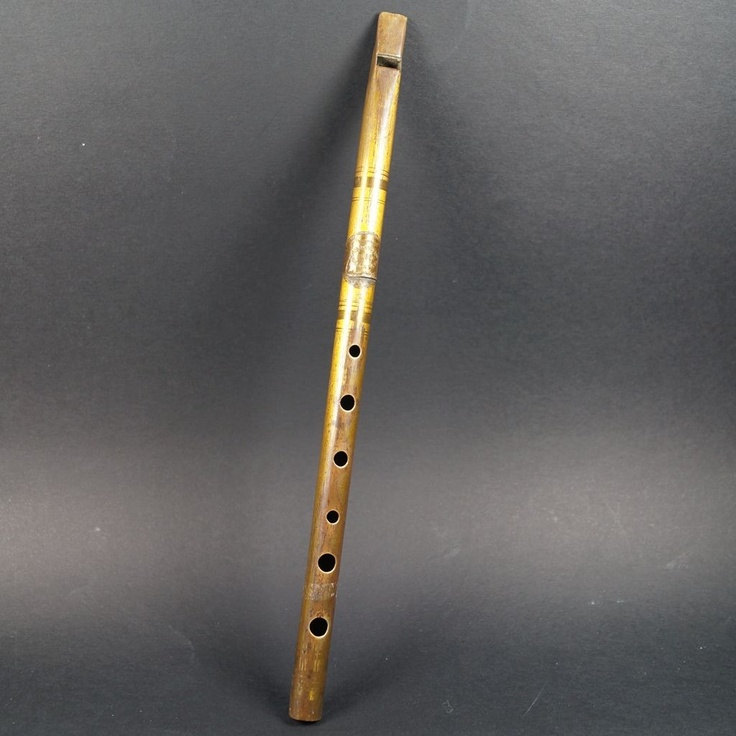 an old wooden flute with holes in it