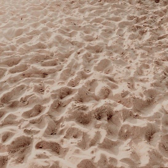 a surfboard is laying on the beach sand