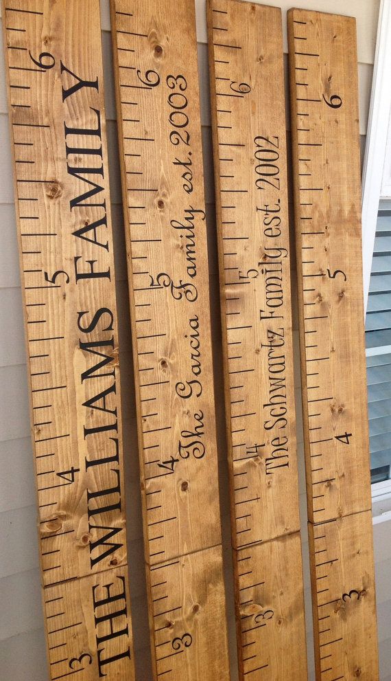 wooden rulers are lined up on the side of a building, with words written on them