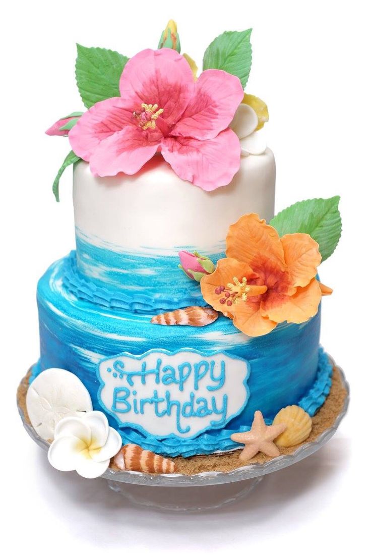 a birthday cake decorated with flowers and seashells