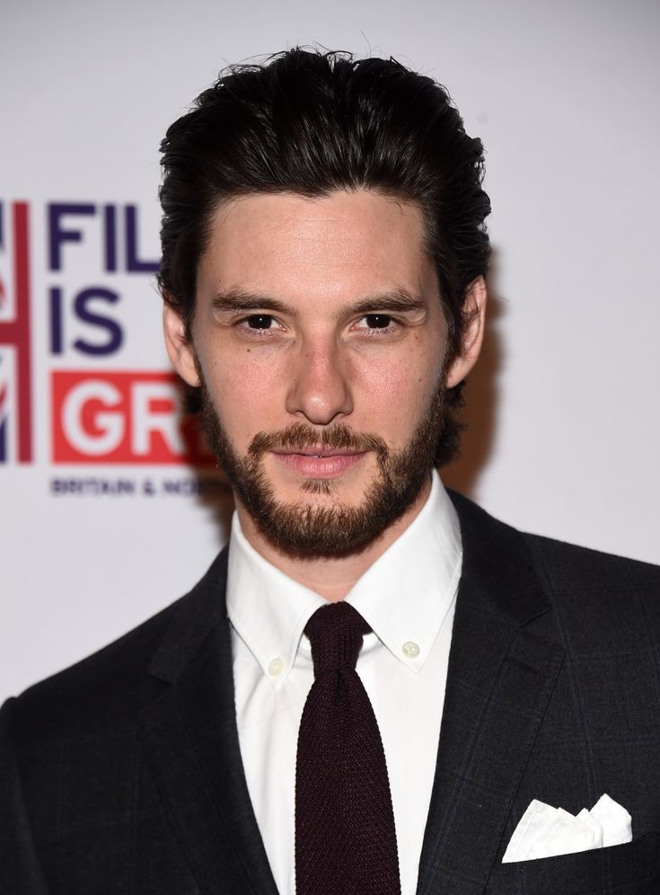 a man in a suit and tie posing for the camera