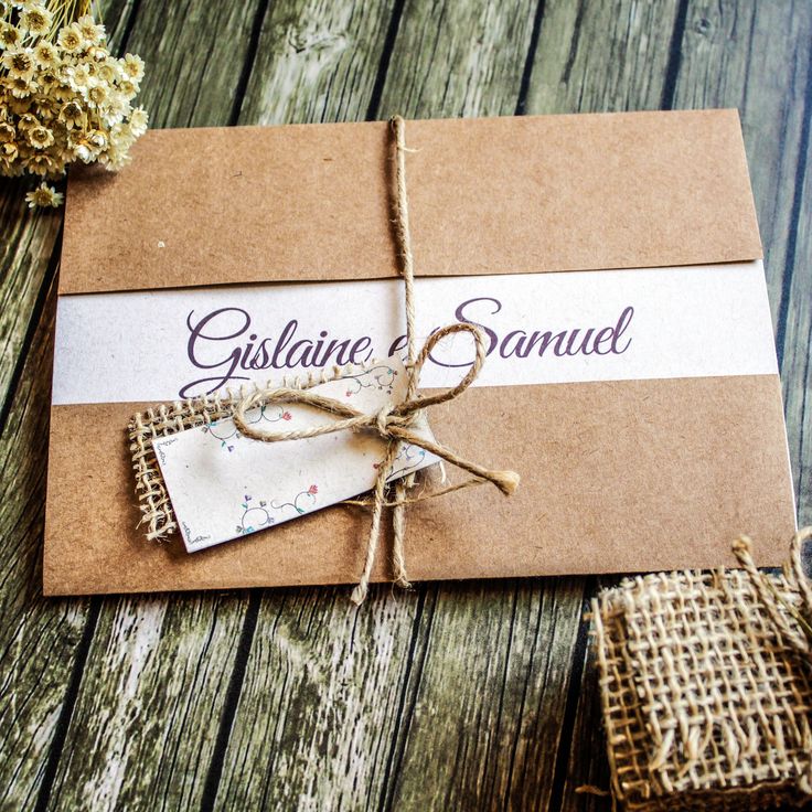 a brown and white wedding card on top of a wooden table next to burlocks