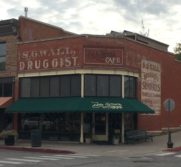 an old red brick building with green awnings