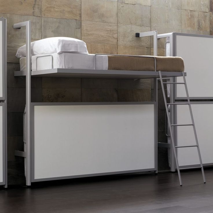 a white bunk bed sitting on top of a hard wood floor next to a wall