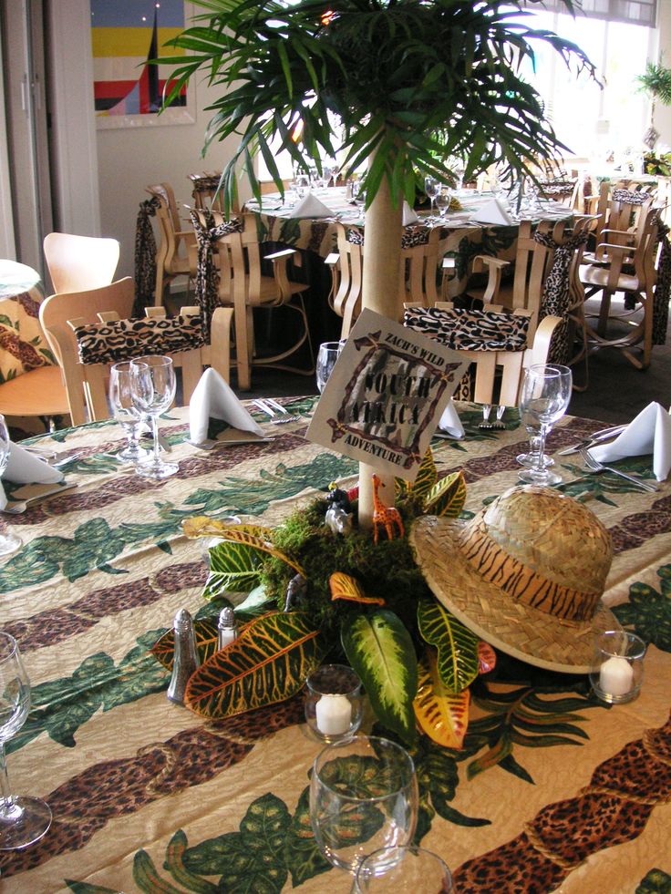 the table is set with place settings for two people to sit at, and there is a palm tree in the center