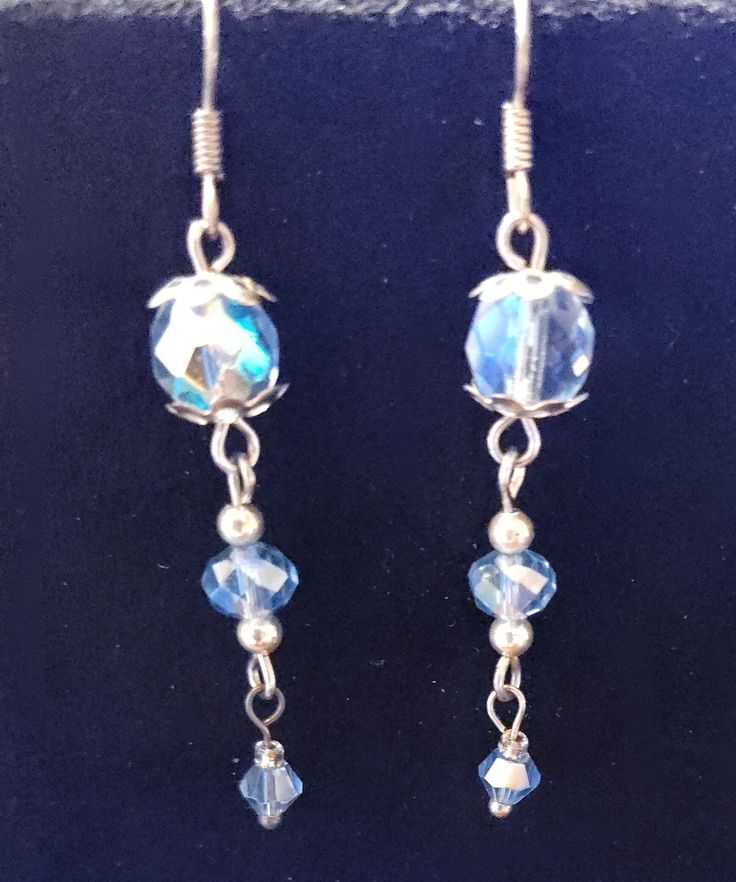 A beautiful pair of silvertone blue crystal earrings. They are silvertone with silver bead caps and spacer beads. As is with all of my jewelry, this is a handmade one-of-a-kind pair of earrings. Thank you for looking and happy shopping. Sterling Silver Faceted Beads Earrings For Gift, Beaded Sterling Silver Crystal Earrings, Metal Beaded Earrings With Faceted Beads For Gifts, Silver Czech Glass Jewelry With Matching Earrings, Adjustable Metal Earrings With Faceted Beads, Sterling Silver Earrings With Faceted Beads For Gifts, Blue Dangle Earrings With Silver Beads, Silver Beaded Dangle Earrings With Faceted Beads, Blue Crystal Earrings With Dangling Beads For Gift