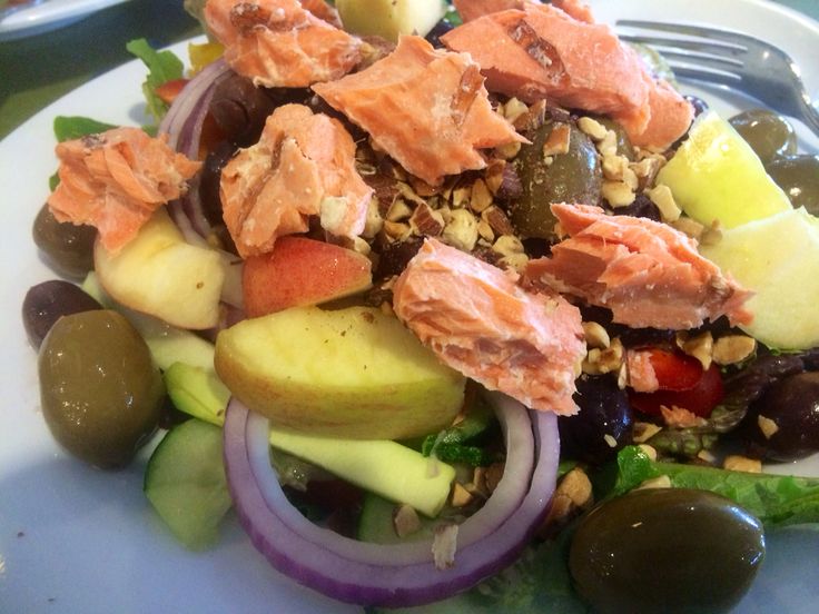 a white plate topped with salad and olives