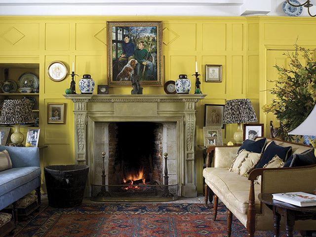 a living room filled with furniture and a fire place next to a painting on the wall