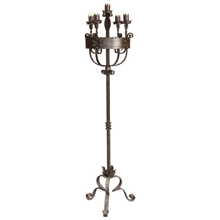 an iron candle holder with five candles on it's stand, and four smaller candles in the middle