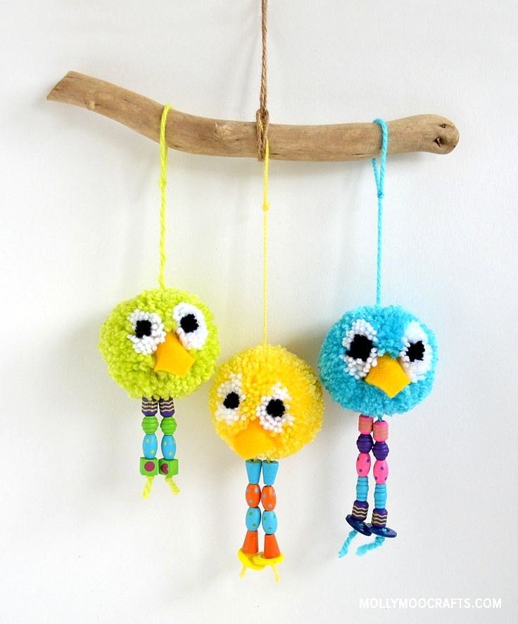 three colorful birds hanging from a tree branch