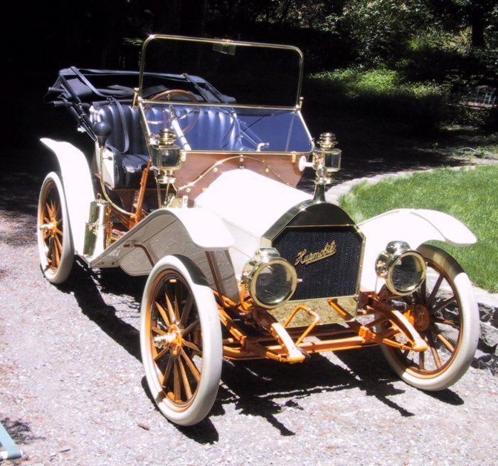 an old model car is parked on the side of the road