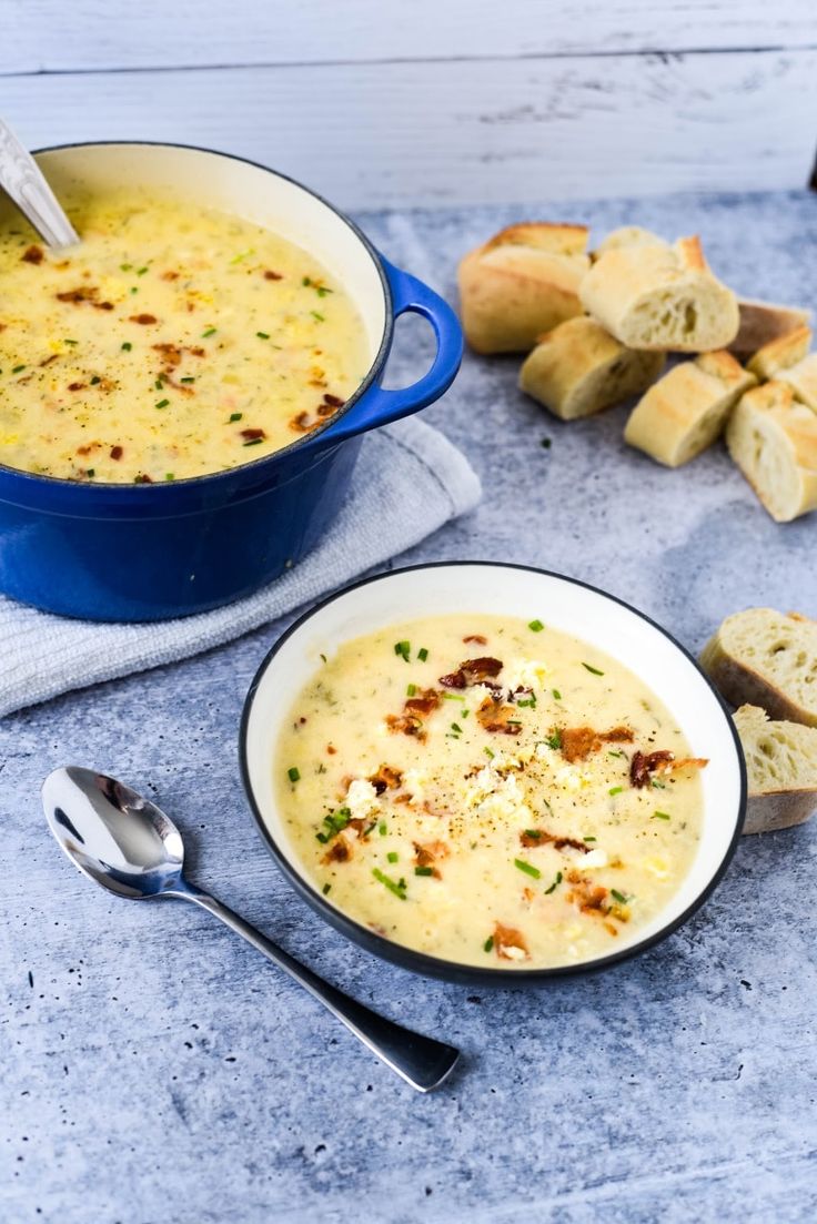 two bowls of soup with bread on the side