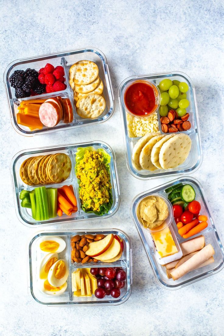 four plastic containers filled with food on top of a white countertop next to an instagram page