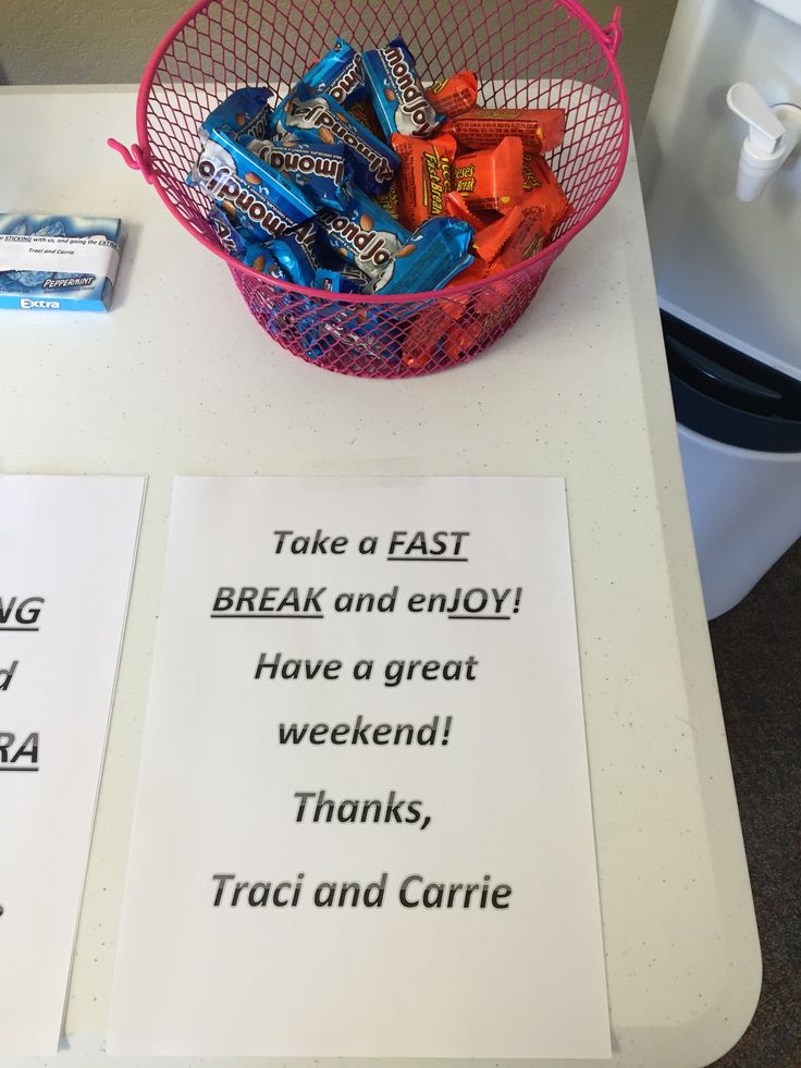 a basket filled with candy sitting on top of a table next to a sign that says take