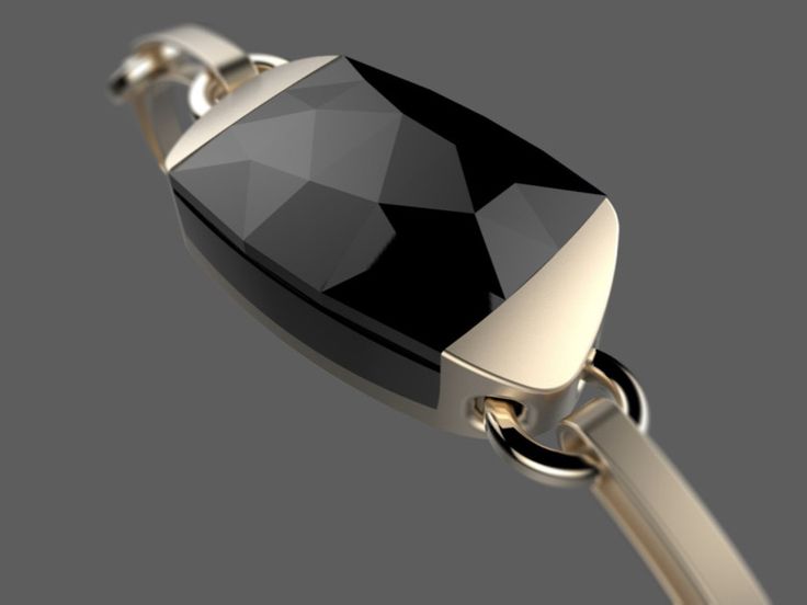 a black and gold ring with a diamond on it's center, hanging from a chain