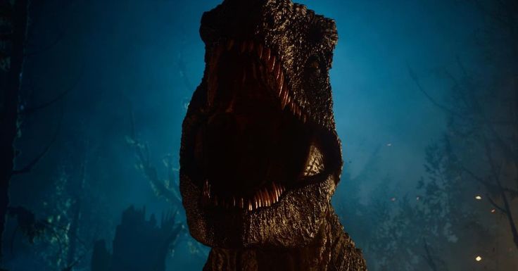 a large dinosaur standing in the middle of a forest at night with its mouth open