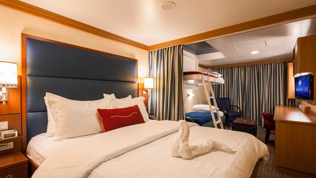 a hotel room with a large bed and a ladder in the corner that is attached to the wall