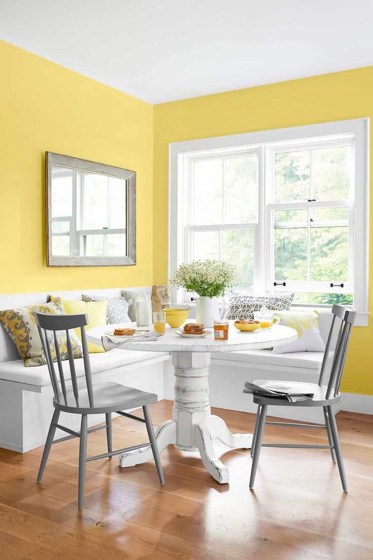 a room with yellow walls and white furniture