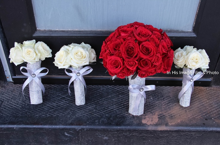 three red and white roses in vases on the front door step with ribbons tied around them