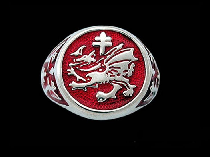 a red and silver ring with a dragon on the center, in front of a black background