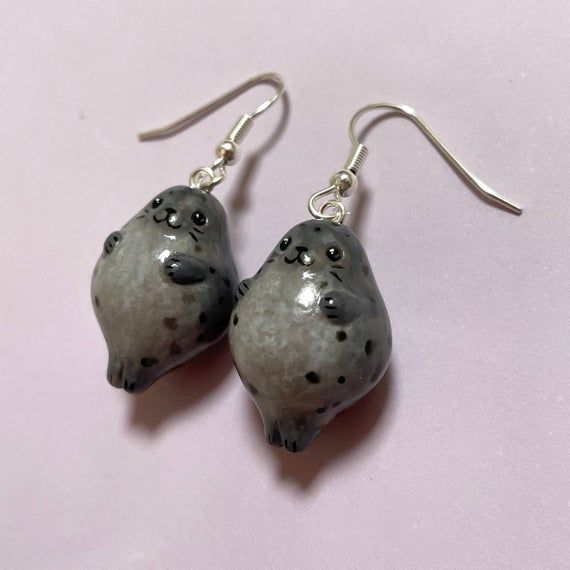 Little grey seal earrings now available in an extra chonky edition!Handmade with polymer clay, acrylic paint, gloss varnish and lots of love. <3Each seal measures roughly 2cm in height and 1.5cm in width.Made with top quality hypoallergenic earring hooks (surgical steel earwires with silver plating.)*As each set is a unique, hand crafted piece, details may vary slightly from the images shown.--------------------------------------------------These cuties ship with tracking so you can always ke Mouse Head Earrings Polymer Clay, Seal Kawaii, Seal Earrings, Grey Seal, Sea Mammal, Mode Hippie, Kawaii Earrings, Funky Earrings, Polymer Clay Miniatures