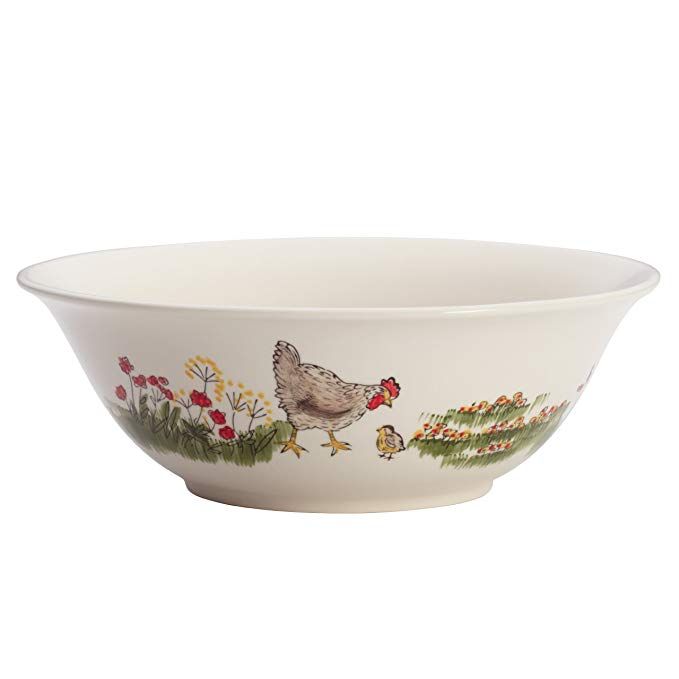 a white bowl with chickens and flowers painted on the side, sitting in front of a white background