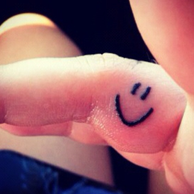 a person's finger with a smiley face drawn on it