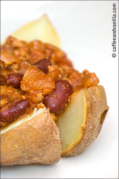 a hot dog covered in chili and potatoes