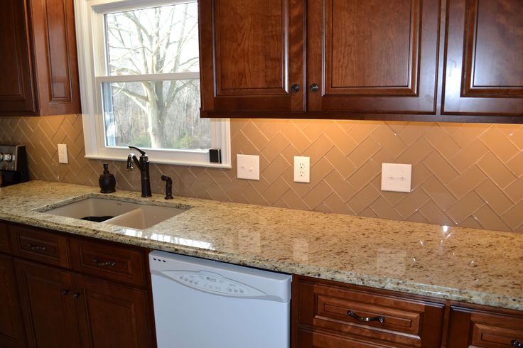 a clean kitchen with wooden cabinets and granite counter tops, white dishwasher in the middle