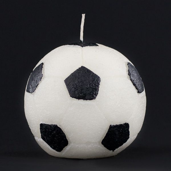 a white and black soccer ball on a black background with one candle in the shape of an apple