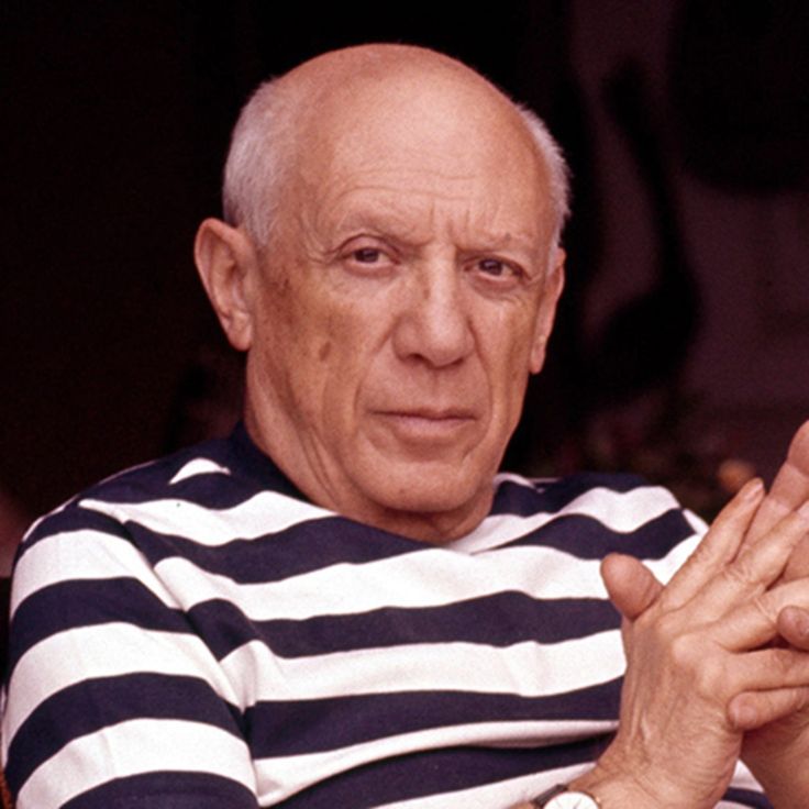 an older man in striped shirt holding his hands together